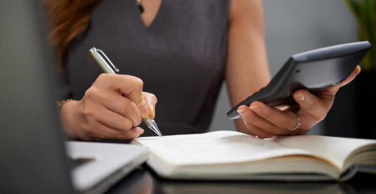 Profissional fazendo cálculos para decidir entre Lucro Presumido ou Lucro Real para o negócio