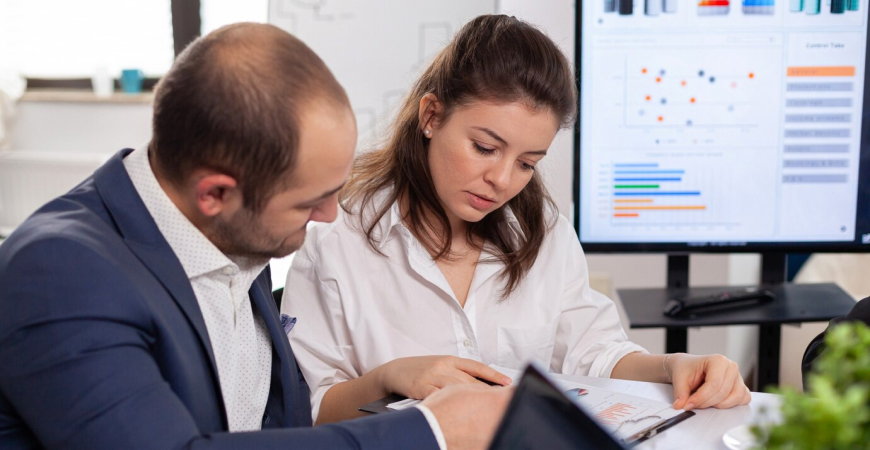 Dois profissionais analisando documentos sobre Lucro Real quando vale a pena adotar o regime tributário