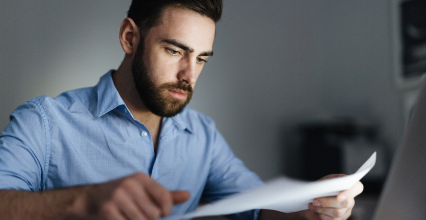 Profissional analisando documentos sobre Você pode estar pagando imposto a mais e revisão do enquadramento tributário