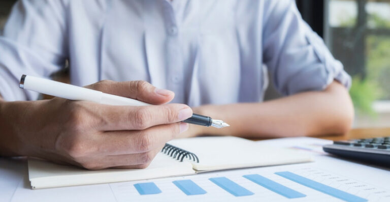 Profissional analisando gráficos e relatórios financeiros, representando os 5 relatórios contábeis que todo empresário deve acompanhar.